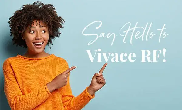 Horizontal shot pleased dark skinned female with Afro haircut, points away with both fore fingers, shows blank space for your promotion, isolated over blue background. People, advertisement concept Bella Institute